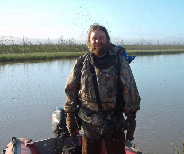 Fletcher Smith in the field Zodiac near shorebird base camp within the Mackenzie Delta.