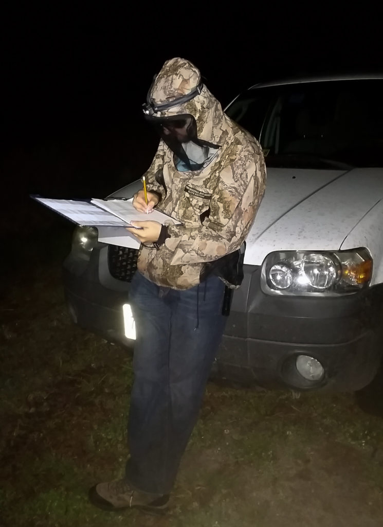 Eric Sibbald conducts a ground-based survey along the edge of a marsh